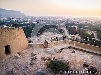 Couple enjoying sunset view from Dhayah fort in the UAE Stock Photo
