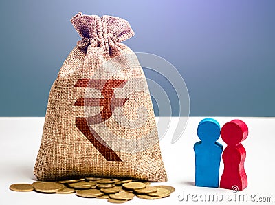 Couple figurines and indian rupee money bag. Budget. Social research, consumer preferences. Segmentation. Marketing and targeting Stock Photo