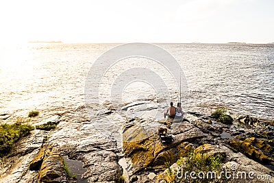 Couple fishing in the ocean during sunset Editorial Stock Photo