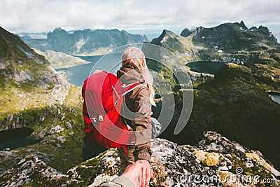 Couple follow holding hands on cliff mountain in Norway Stock Photo