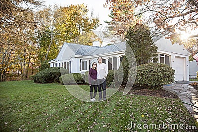 Couple standing in yard in front of house Stock Photo