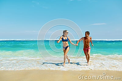 Couple Fun On Beach. Romantic People In Love Running At Sea Stock Photo