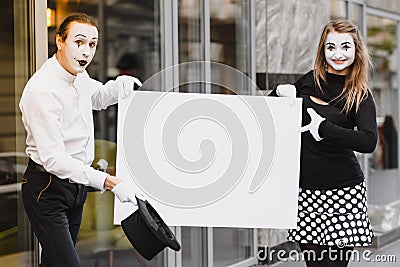 Couple funny mimes holding sign Stock Photo