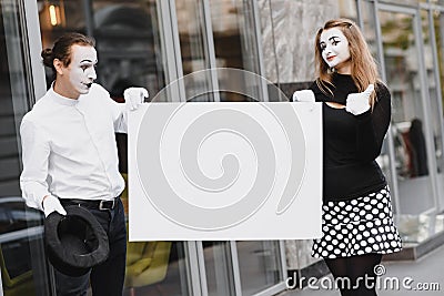 Couple funny mimes holding sign Stock Photo