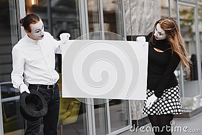 Couple funny mimes holding sign Stock Photo