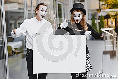 Couple funny mimes holding sign Stock Photo