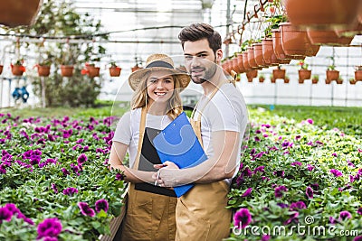 Couple of gardeners holding clipboards by flowers Stock Photo