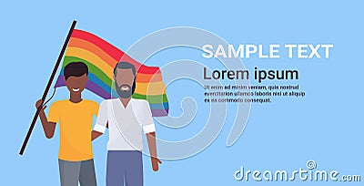 Couple gays holding lgbt rainbow flag love parade pride festival concept two smiling guys embracing male cartoon Vector Illustration