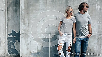 Couple in gray t-shirt over street wall Stock Photo