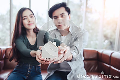 Couple Hands Holding Housing Model for Future Real Estate Saving, Attractive Asian Couple Hand Joint to Protection Home Property Stock Photo