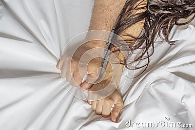 Couple hands pulling white sheets in ecstasy, orgasm. Concept of passion. Oorgasm. Erotic moments. Intimate concept. Sex Stock Photo