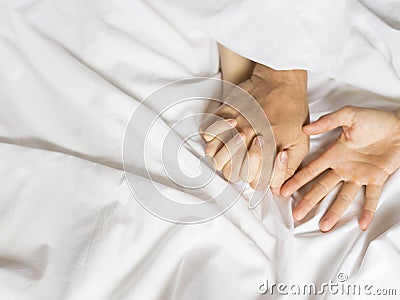 Couple hands pulling white sheets in ecstasy, orgasm. Concept of passion. Orgasm. Erotic moments. Intimate concept. Sex Stock Photo