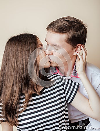 Couple of happy smiling teenagers students, warm colors having a kiss, lifestyle people concept Stock Photo