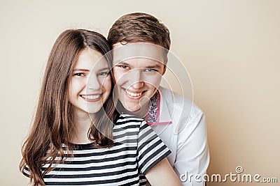 Couple of happy smiling teenagers students, warm colors having a kiss, lifestyle people concept Stock Photo