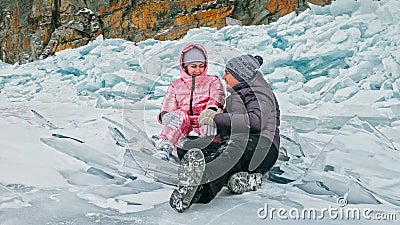 Couple has fun during winter walk against background of ice of f Stock Photo
