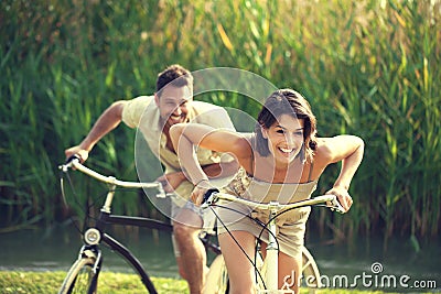 Couple having a bicycles race into the nature in Garda Lake Stock Photo