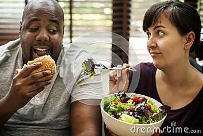 Couple having fast food on the couch Stock Photo