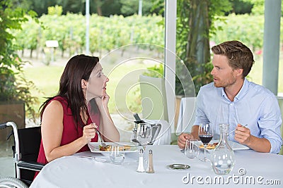 Couple having meal in restaurant lady in wheelchair Stock Photo