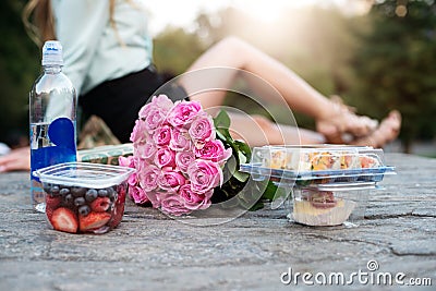 Couple having romantic picnic date in the park with food, drinks and flower Stock Photo
