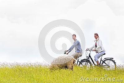 Couple having sea coast bicycle tour at levee Stock Photo