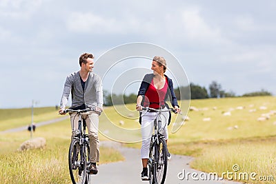 Couple having sea coast bicycle tour at levee Stock Photo