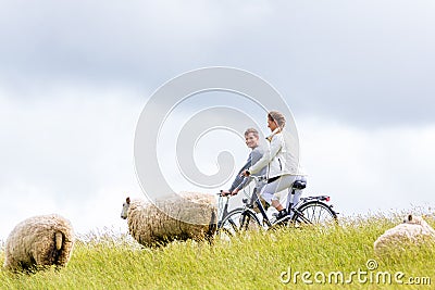 Couple having sea coast bicycle tour at levee Stock Photo