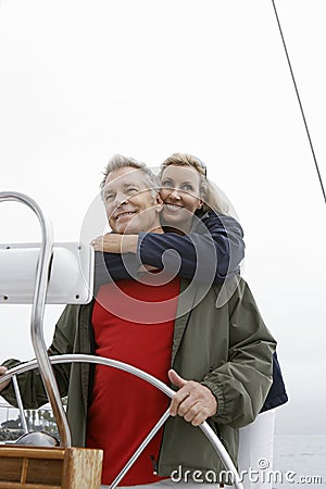 Couple At Helm Of Sailboat Stock Photo