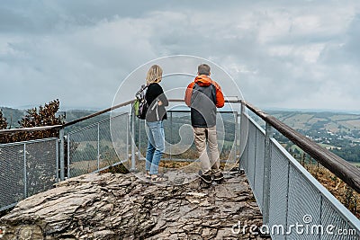 Couple of hikers together enjoying view of nature.Autumn fall outdoor cold season.Man and woman backpackers on viewing platform. Stock Photo