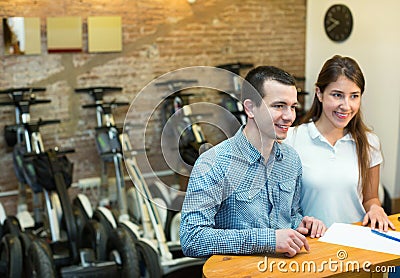 Couple hiring segways ot rental store Stock Photo