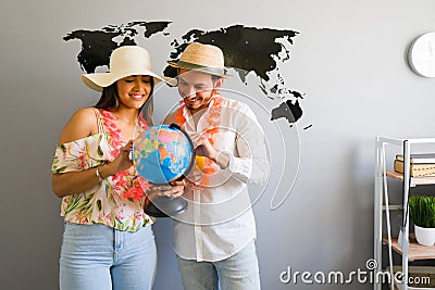 Couple holding a globe with a world map in the background Stock Photo