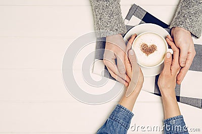 Couple holding hands with coffee on white table, top view Stock Photo