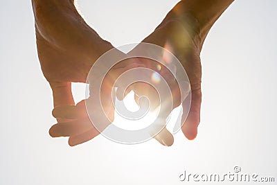 Couple holding hands toward the sun Stock Photo