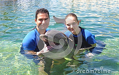 Couple Holding a Smiling Dolphin ! Stock Photo