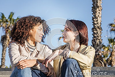 Couple of homosexual women talking sitting Stock Photo