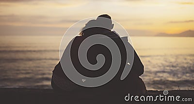 Couple hugging on background beach ocean sunrise, silhouette two romantic people cuddling and looking on rear view evening sea Stock Photo