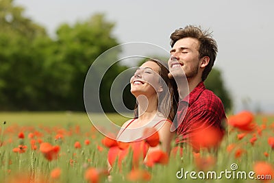 Couple hugging and breathing fresh air in a red field Stock Photo