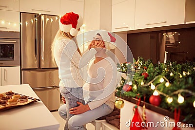 Couple hugging in the kitchen with lights for Christmas Stock Photo