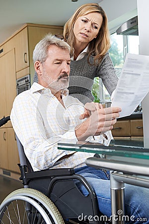 Couple With Husband In Wheelchair Reading Letter Stock Photo