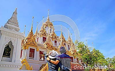 Couple Impressed by the Amazing Loha Prasat which Adorned with 37 Golden Spires inside Wat Ratchanatdaram Temple Stock Photo