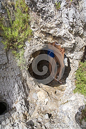 Couple inside a cave in the cliff. Clifftop, tourism. Stock Photo