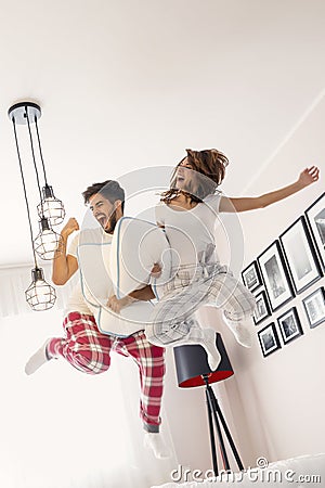 Couple jumping on bed Stock Photo