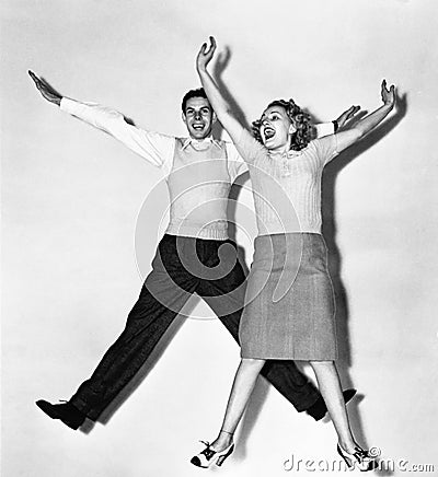 Couple jumping with their arms outstretched Stock Photo