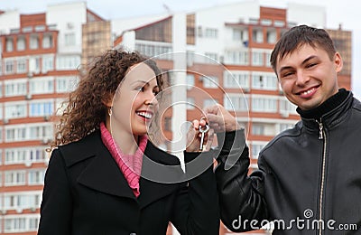 Couple with key against many-storeyed house Stock Photo