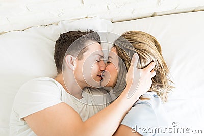 Couple Kissing While Lying In Bed Stock Photo