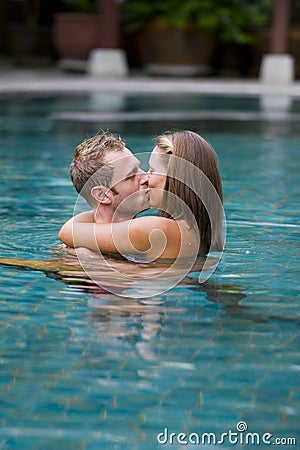 Couple kissing in swimming pool Stock Photo