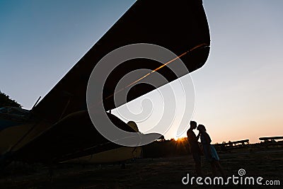 Couple is kissing under the vintage plane Stock Photo