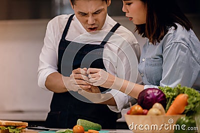 Couple in the Kitchen. Accident while Preparing Food Stock Photo
