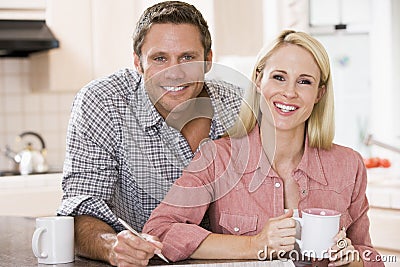 Couple in kitchen with newspaper with coffee Stock Photo