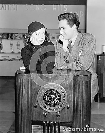 Couple leaning on a radio and looking at each other Stock Photo