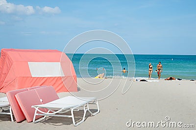 Couple leave water walking back to thier towels on beach while p Editorial Stock Photo